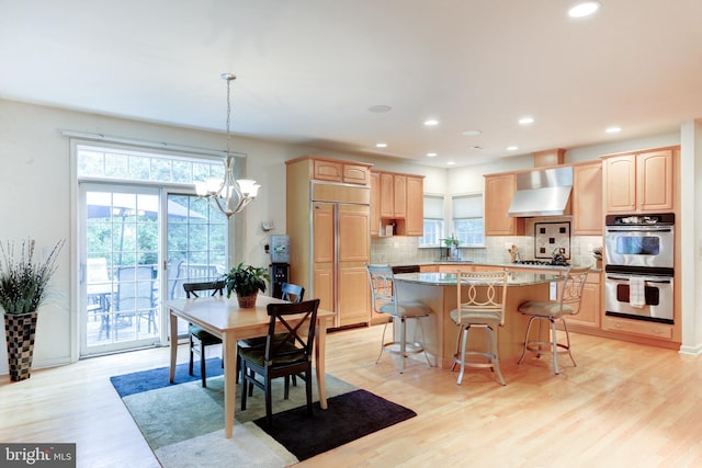 dining space with an inviting chandelier, light wood-type flooring, and sink