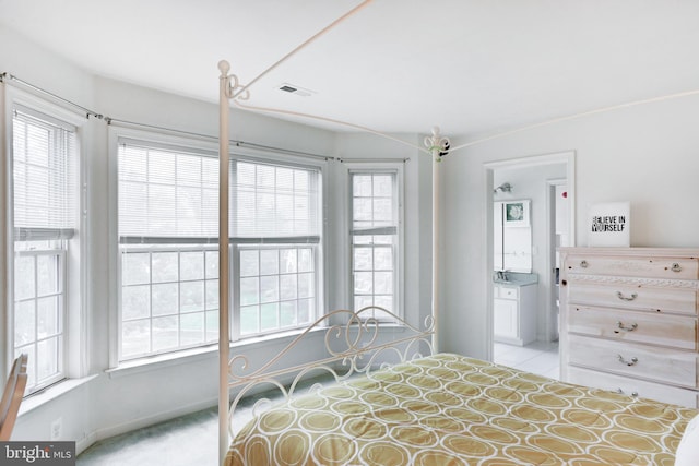 carpeted bedroom featuring ensuite bath