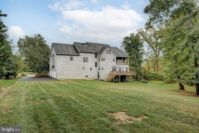 back of property featuring a deck, stairway, and a yard