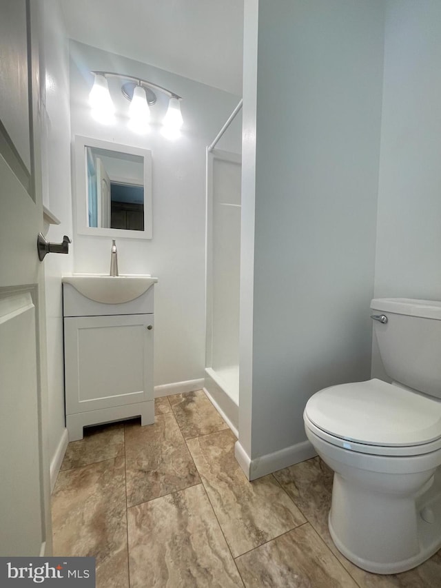 bathroom with tile patterned flooring, toilet, vanity, and walk in shower