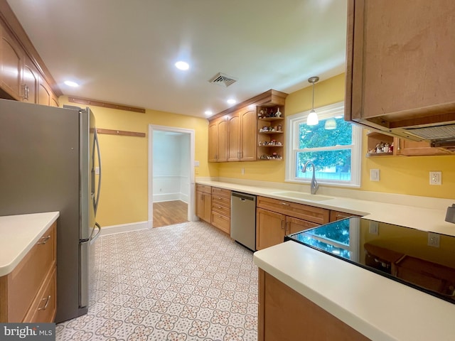 kitchen with appliances with stainless steel finishes, decorative light fixtures, light countertops, open shelves, and a sink