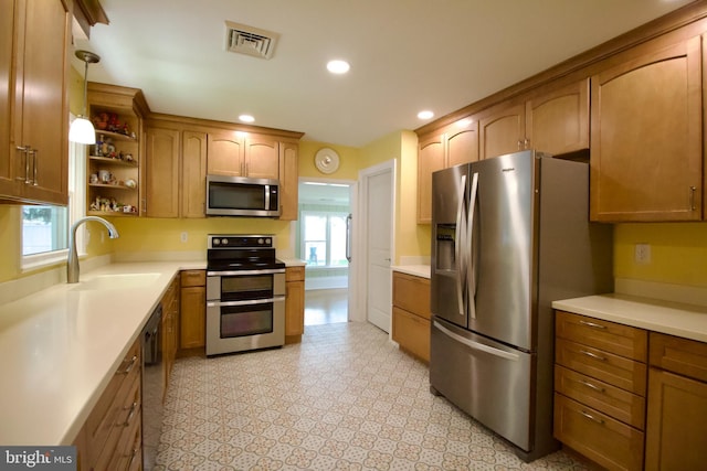 kitchen featuring sink, light tile patterned flooring, pendant lighting, and stainless steel appliances