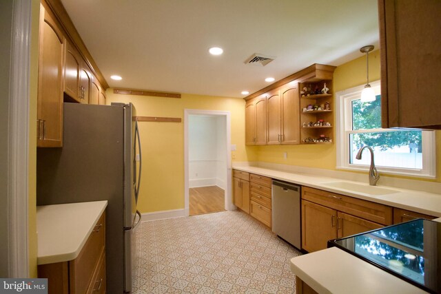 kitchen with light tile patterned flooring, sink, stainless steel appliances, and pendant lighting