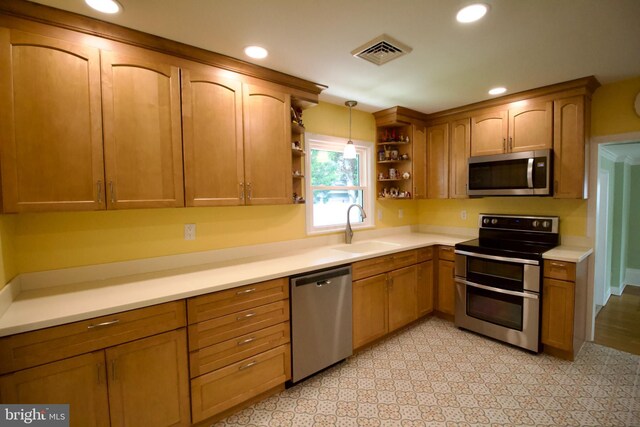 kitchen featuring sink, light tile patterned flooring, appliances with stainless steel finishes, and pendant lighting