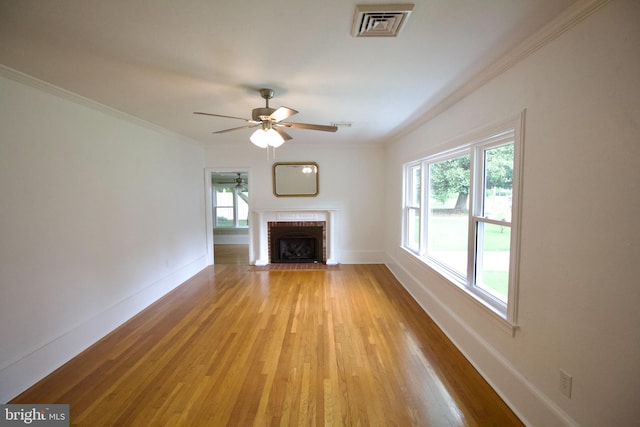 unfurnished living room with a wealth of natural light, light wood-type flooring, and a brick fireplace