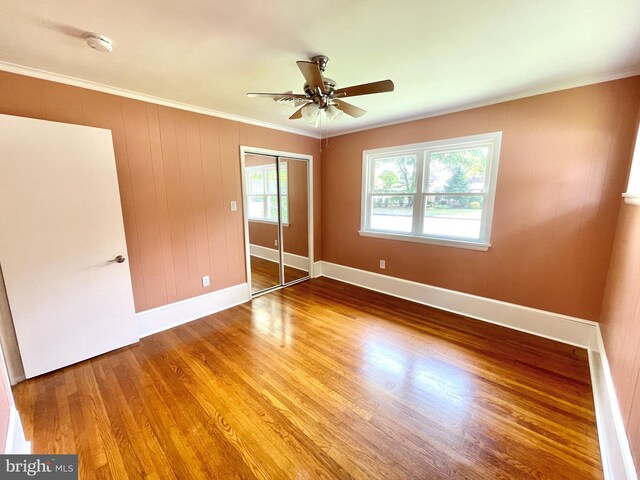 empty room featuring ceiling fan, ornamental molding, and wood-type flooring