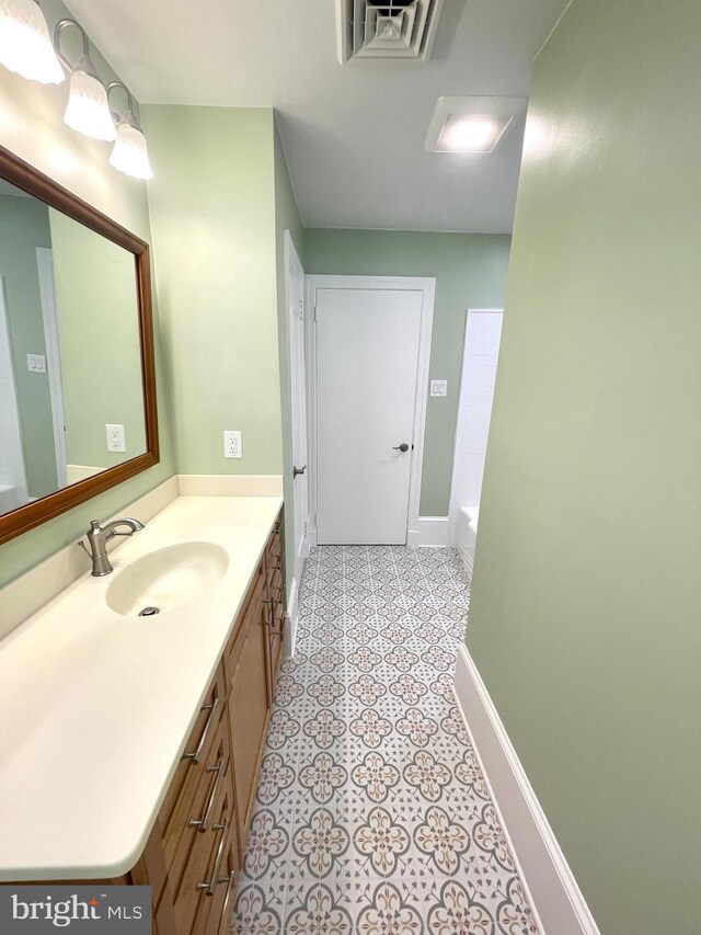 bathroom featuring a bath, tile patterned flooring, and vanity