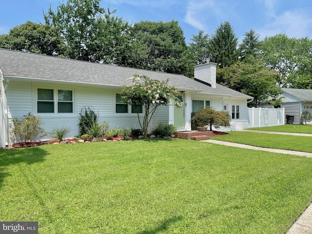 ranch-style home with brick siding, a shingled roof, a chimney, and a front yard