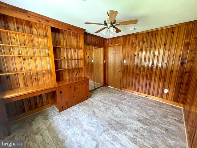 spare room with wood walls, ceiling fan, and tile patterned floors