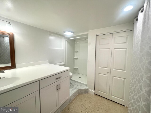 bathroom featuring toilet, vanity, and curtained shower