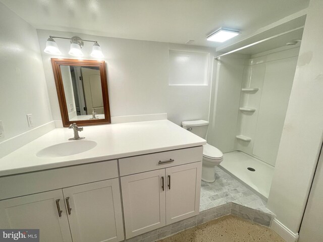 bathroom featuring a shower, vanity, and toilet