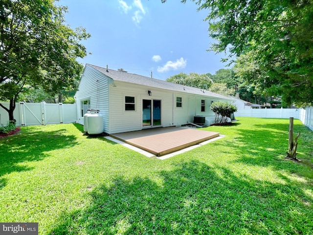 back of house featuring a wooden deck, central AC unit, and a yard