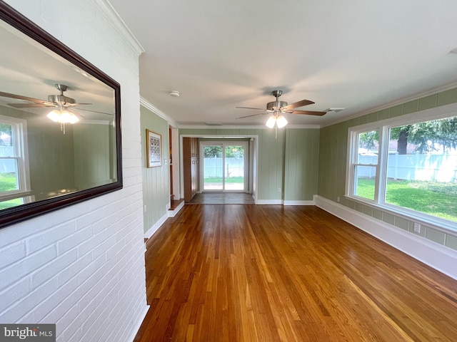 unfurnished room featuring a ceiling fan, crown molding, baseboards, and wood finished floors