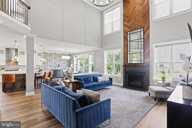 living room featuring wood finished floors, a fireplace with flush hearth, and an inviting chandelier