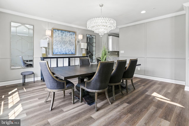 dining space with ornamental molding, a decorative wall, and wood finished floors