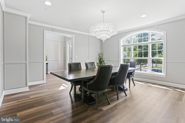 dining space with a notable chandelier, crown molding, and wood finished floors