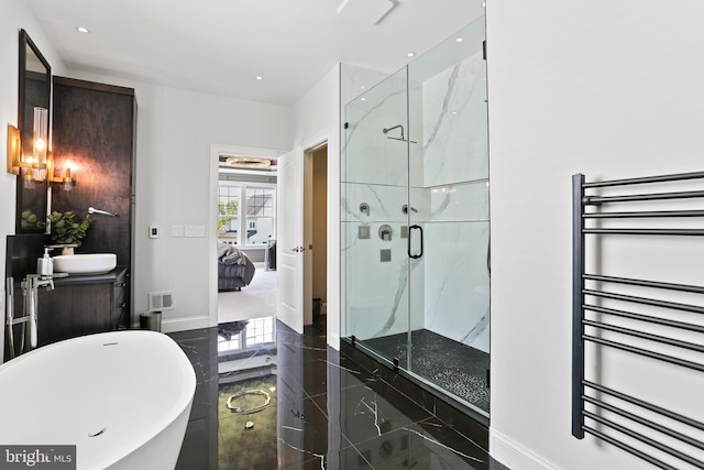 ensuite bathroom with marble finish floor, visible vents, radiator heating unit, a sink, and ensuite bath