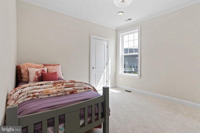 carpeted bedroom with baseboards, visible vents, and crown molding