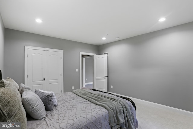 bedroom featuring light carpet, baseboards, a closet, and recessed lighting