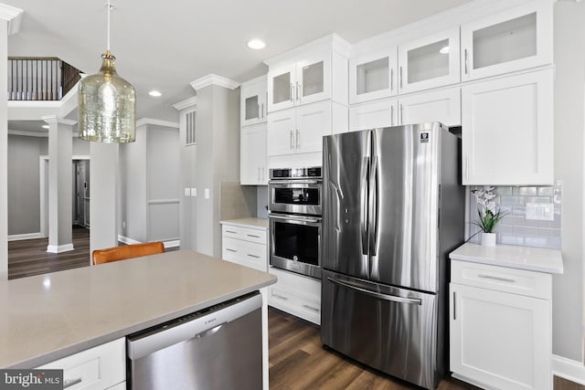 kitchen featuring appliances with stainless steel finishes, light countertops, white cabinets, and glass insert cabinets