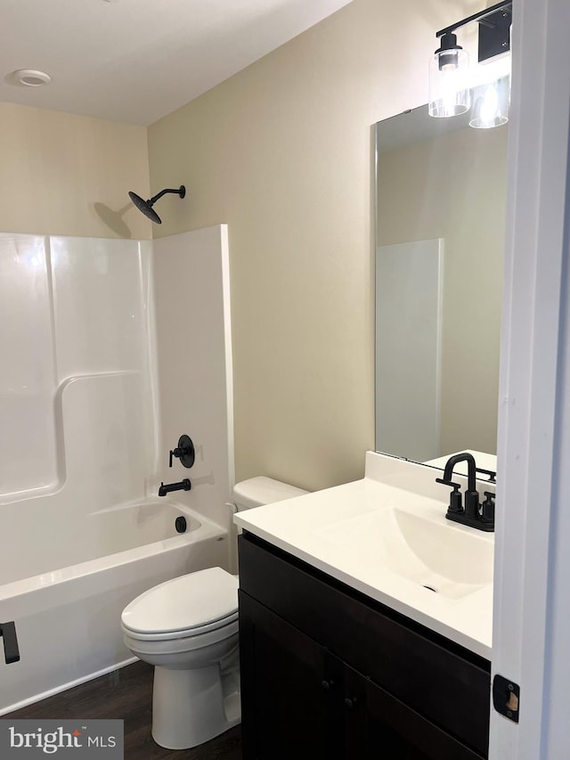 full bathroom with hardwood / wood-style flooring, vanity, toilet, and tub / shower combination