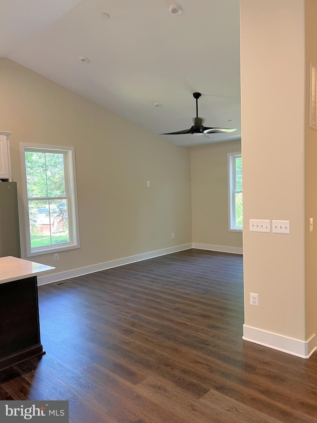 unfurnished living room featuring vaulted ceiling, dark hardwood / wood-style floors, and ceiling fan