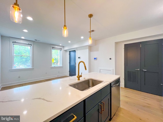 kitchen featuring sink, stainless steel dishwasher, pendant lighting, and light wood-type flooring