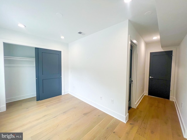 unfurnished bedroom featuring a closet and light wood-type flooring