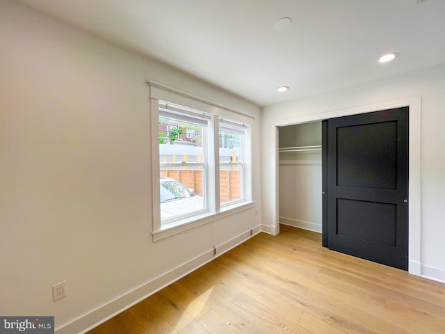 unfurnished bedroom with light hardwood / wood-style flooring and a closet