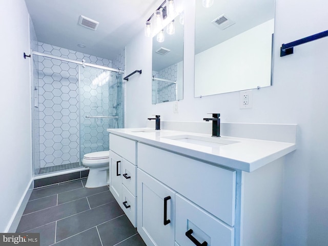 bathroom with an enclosed shower, tile patterned flooring, dual bowl vanity, and toilet