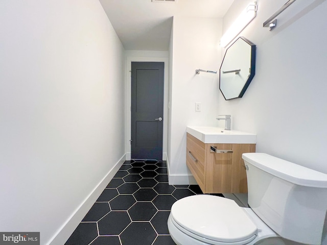 bathroom featuring vanity, tile patterned floors, and toilet