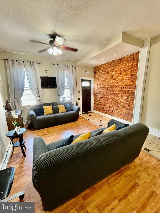 living room featuring hardwood / wood-style floors, a textured ceiling, and ceiling fan