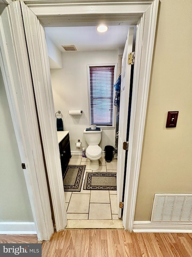 bathroom featuring vanity, hardwood / wood-style floors, and toilet