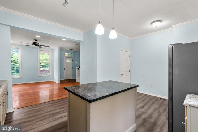 kitchen featuring a kitchen island, stainless steel refrigerator, decorative light fixtures, white cabinetry, and dark hardwood / wood-style flooring