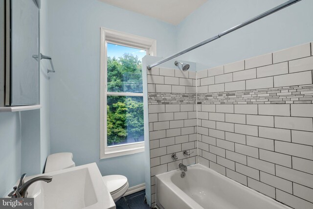 full bathroom with sink, tiled shower / bath, and toilet