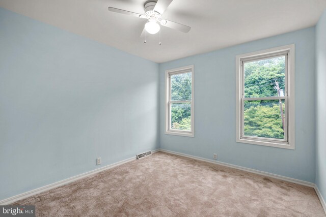 spare room featuring light colored carpet and ceiling fan