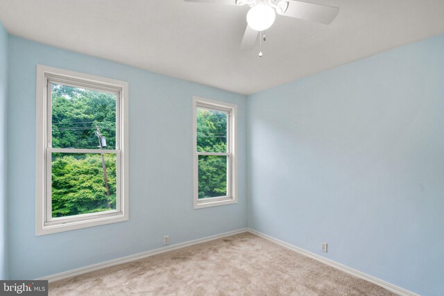 carpeted spare room with ceiling fan