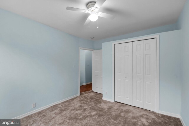 unfurnished bedroom featuring carpet, ceiling fan, and a closet