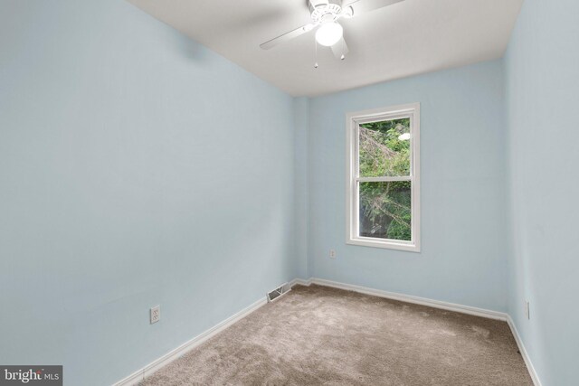 empty room with ceiling fan and carpet floors