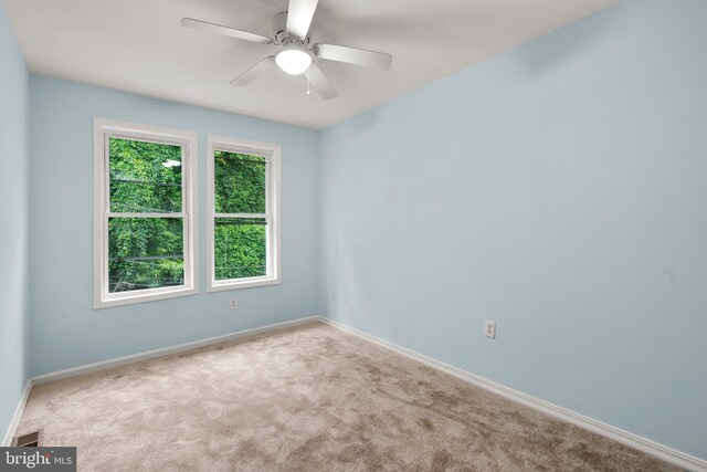 spare room with ceiling fan and carpet