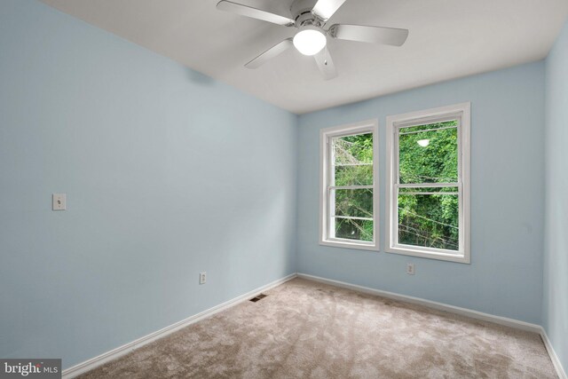 carpeted spare room featuring ceiling fan