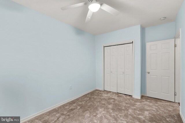 unfurnished bedroom with light carpet, a closet, and ceiling fan