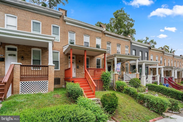 view of property featuring a front yard and covered porch