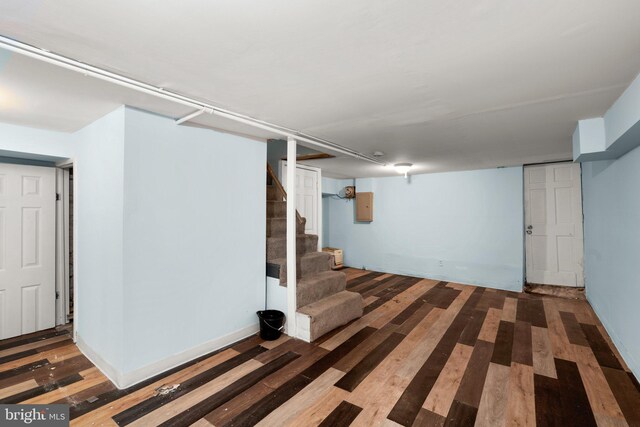 basement with hardwood / wood-style floors and electric panel