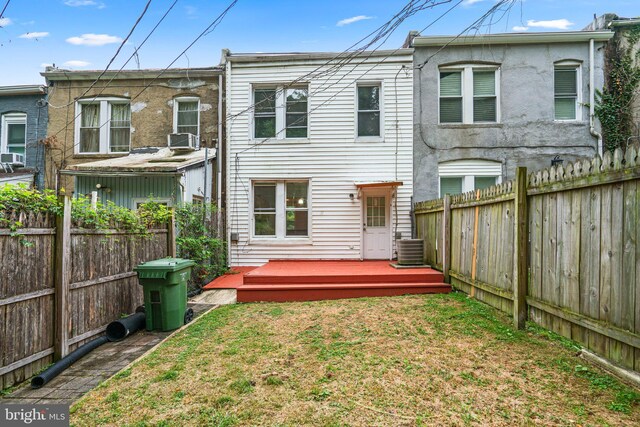 back of property featuring cooling unit and a lawn