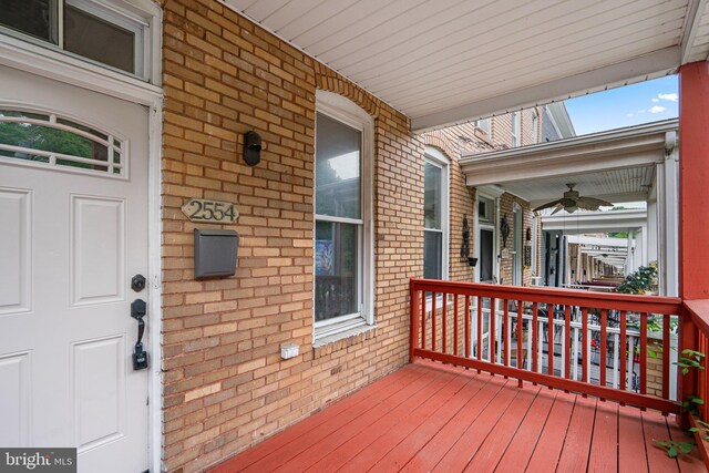 wooden terrace with ceiling fan and covered porch