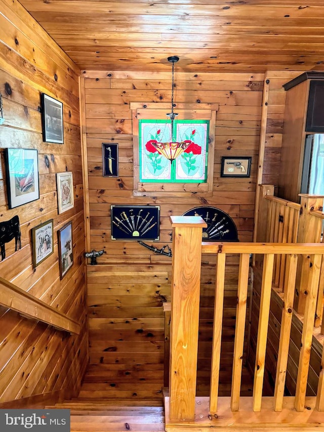 interior space with hardwood / wood-style flooring and wooden walls