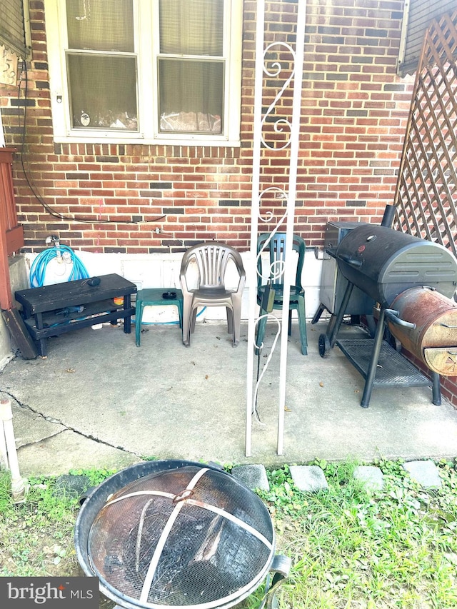 view of patio with an outdoor living space with a fire pit