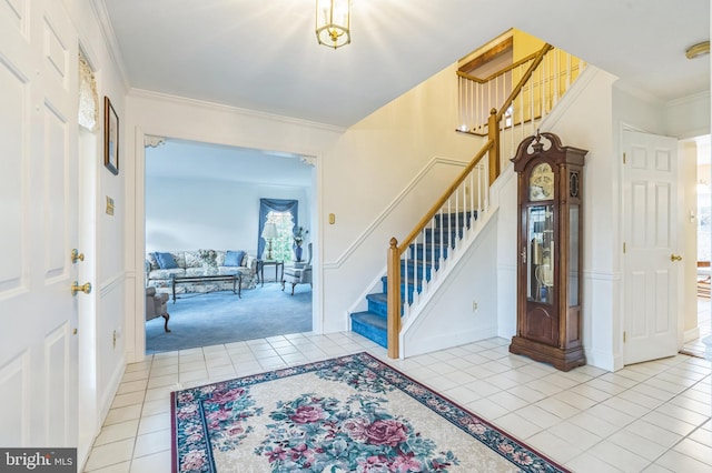 carpeted foyer entrance with ornamental molding