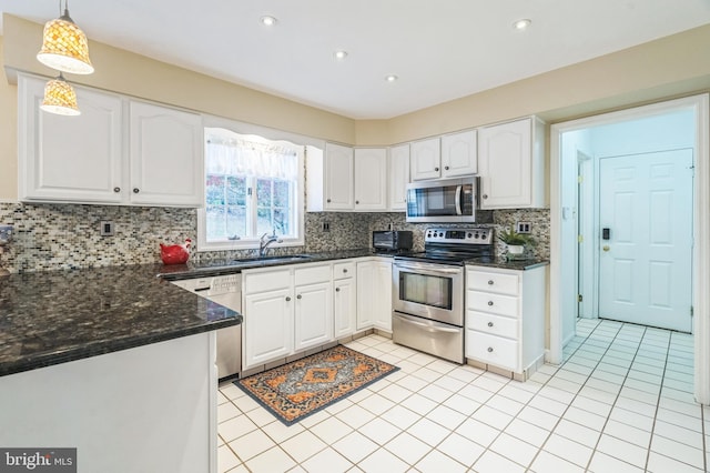 kitchen featuring sink, stainless steel appliances, backsplash, decorative light fixtures, and white cabinets